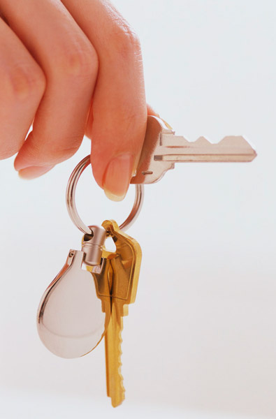 House key opening a front door of a new property